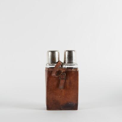 A Vintage Travel Bottles With A Leather Holster
