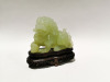 A Chinese Light Green Jade Carving of Lion Dog with Wooden Base