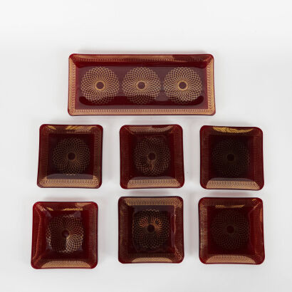 A Mid Century Red Glass 7-Piece Plate Set With Gold Detail