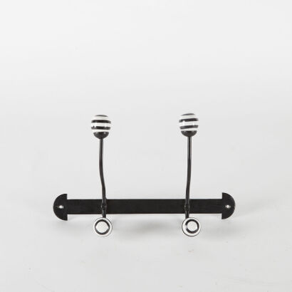 A Wrought Iron Double Coat Hook With Striped Ceramic Knobs