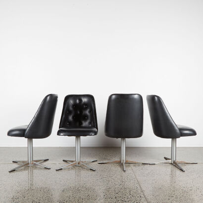 A Set Of Four Mid-Century Dining Chairs In Black Button Back Upholstery With Swivel Metal Base