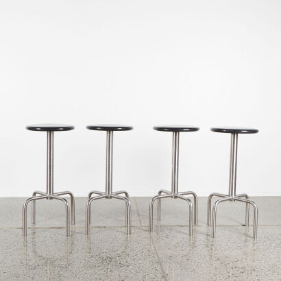 A Set Of Four Minimalist Barstools With Stainless Base And Black Seat