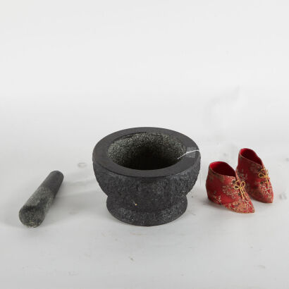 A Large Mortar And Pestle And A Pair Of Small Decorative Shoes