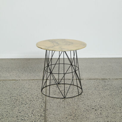 A Circular Side Table With Black Geometric Base And Faux Marble Top