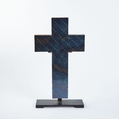 A Large Sculptured Metal Cross On A Stand