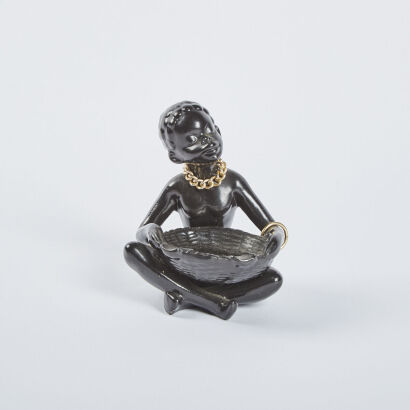 A Ceramic Figure Of An African Woman With Basket