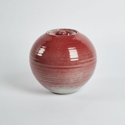 An Orbular Red Vase With Lid