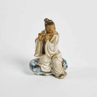 A Ceramic Figure Of A Scholar Playing The Flute