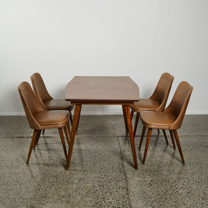 A Retro Dining Table With Four Vinyl Chairs