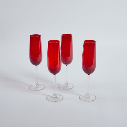 A Set Of Four Red Glass Champagne Flutes