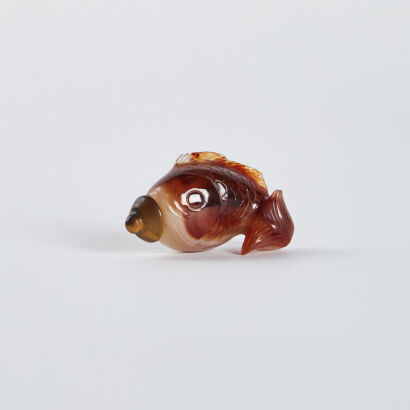 A Chinese silk red agate snuff bottle in the form of a fish