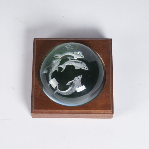 A Glass Paperweight With Dolphin Engraving