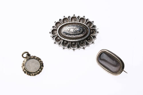 A Victorian sterling silver brooch and a rolled gold mourning locket and brooch, both with hair inserts. Length of silver brooch 4cm.