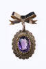 An Edwardian amethyst brooch, the oval amethyst, estimated 17mm x 10mm in sawtooth claw mount set as pendant /bow brooch. 9ct rose gold. Weight 7.5 grams. Length 45mm. Circa 1910.