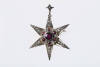 A Victorian garnet and pearl pendant brooch, the six pointed star is bead set with half seed pearls and garnets. 9ct yellow gold. &nbsp;Weight 3.0 grams. Width 37mm. &nbsp;Makers tag J.C.N.