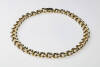 A two tone gold necklace of fancy textured curb link design. 18ct yellow and white gold. Weight 78.09 grams. Length 44cm. Width 11mm.