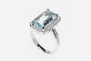 An aquamarine and diamond ring, the central rectangular fancy cut aquamarine of known weight 3.28 carats, four claw set in a diamond frame with diamond set shoulders. Total known diamond weight 0.22 carats. 18ct white gold. Weight 8.7 grams. Size N.