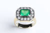 An emerald and diamond ring, the emerald cut emerald of estimated weight &nbsp;3.25 carats surrounded by 14 brilliant cut diamonds of estimated weight 1.68 carats. 18ct white and yellow gold. Weight 14.5 grams. Size T.&nbsp;&nbsp;