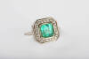 An emerald and diamond ring, the square emerald cut emerald 7.2mm x 6.9mm of estimated weight 1.94 carats surrounded by 24 grain set round brilliant diamonds of estimated weight .32 carats. 14ct white gold. Weight 5.86 grams. Size M.&nbsp;