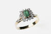 An emerald and diamond cluster ring, the central emerald cut diamond ring in a round brilliant cut diamond set frame. 18ct yellow gold. Weight 4.7 grams. Size S.