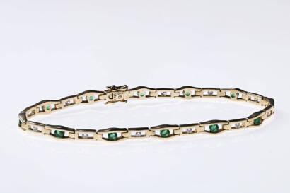 An emerald and diamond bracelet, the twelve round emeralds and alternating diamonds are bezel set in an articulated links. 14ct yellow gold. Length 175mm. Weight 8.5 grams.