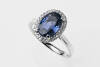 A sapphire and diamond ring, of traditional cluster design. The oval blue sapphire of known weight 2.83 carats, in diamond set frame. Known total diamond weight 0.20 carat. 18ct white gold. Weight 4.7grams. Size O.