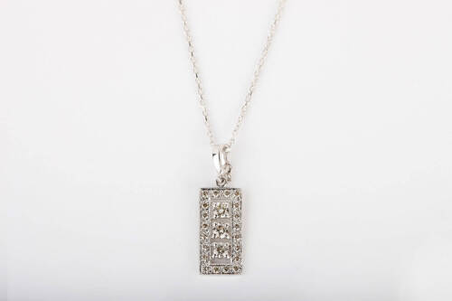 A diamond pendant, of rectangular design, with a line of three round brilliant cut diamonds in diamond frame. Known total diamond weight 0.50 carat. 9ct white gold. Weight 1.5 grams. Length 28mm. To be sold with a fine trace link chain. 18ct white gold. W