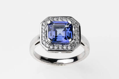 A tanzanite and diamond ring, of traditional square cluster design. The central step cut tanzanite of known weight 2.39 carats, in diamond set frame. Estimated total diamond weight 0.25 carat. 18ct white gold. Weight 6.6 grams. Size N.