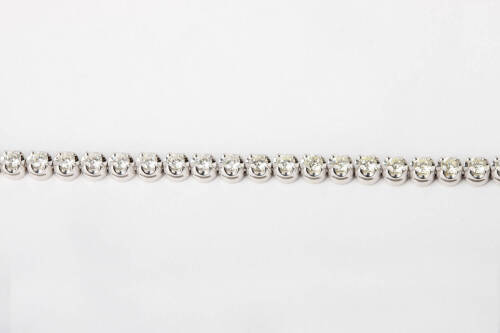 A diamond line bracelet, the thirty-four round brilliant diamonds of known total weight 5 carats. 18ct white gold. Length 17cm.