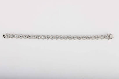 A diamond bracelet, of articulated design, with twenty-three circular diamond cluster panels. Total known diamond weight 9 carats. 18ct white gold. Weight 22.1 grams. Length 17.5cm.