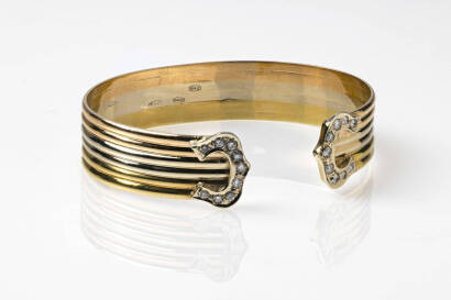 A gold and diamond bangle, the oval three tone torc bangle consisting of fluted bands of pink, yellow and white gold each end with a buckle shaped head set with nine round brilliant diamonds of total weight 0.48 carat. 18ct gold. Weight 40.8 grams.
