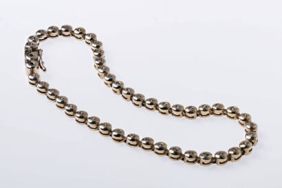A yellow gold and diamond line bracelet, 45 round brilliant diamonds of estimated total weight 0.50 carat are set in linked collet mounts. 9ct yellow gold. Weight 8.62 grams. Length 17cm.