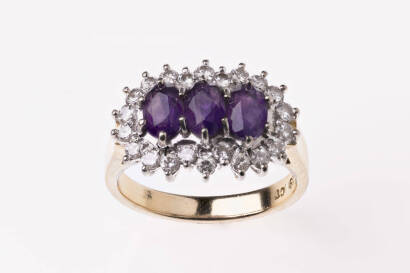 An amethyst and diamond ring, the three oval amethysts surrounded by a border of round brilliant cut diamonds. 18ct yellow and white gold. Weight 6.8 grams. Size P.&nbsp;