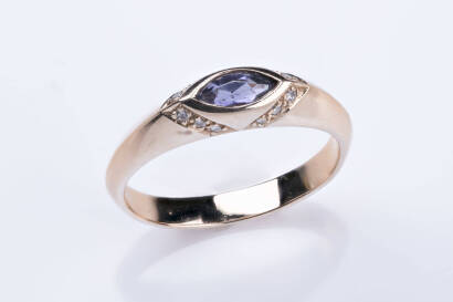 A sapphire and diamond ring, the marquise cut purple sapphire bezel set with a surround of bead set diamonds in profile. 18ct rose gold. Weight 4.17 grams. Size N&frac12;.