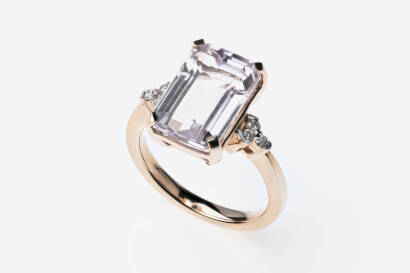 A kunzite and diamond ring, four claw set with a rectangular step cut kunzite of known weight 7.35 carats, three small brilliant cut diamonds to each shoulder.&nbsp;18ct rose gold. Weight 6.6 grams. Size N.