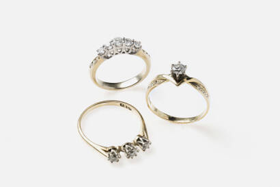 Three diamond rings, one ring with five graduated round brilliant diamonds, one with three round brilliant diamonds and the other a round brilliant diamond solitaire of estimated weight 0.20 carat. Two rings 18ct yellow and white gold, the other unmarked.