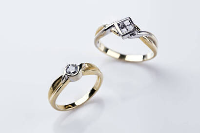 Two diamond rings. One bezel set with a brilliant cut diamond of estimated weight 0.20 carat. To be sold with a diamond ring, square set with four princess cut diamonds. 18ct yellow gold. Total weight 6.39 grams. Sizes I&frac12; and N&frac12;.