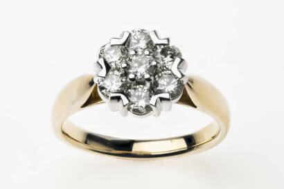 A diamond ring, of cluster design, set with seven round brilliant cut diamonds of total known weight 1.0 carat. 18ct yellow gold. Weight 5.8 grams. Size O.