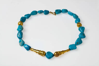 A gold and turquoise necklace, nineteen turquoise beads strung between two round and two oblong engraved gold beads. 22ct yellow gold. Length 43cm.