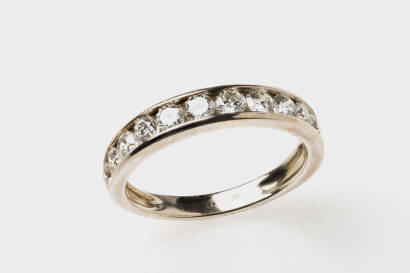 A diamond band ring, the front section channel set with 12 round brilliant diamonds of estimated weight 0.80 carat. 9ct yellow gold. Weight 2.41 grams. Size P.&nbsp;