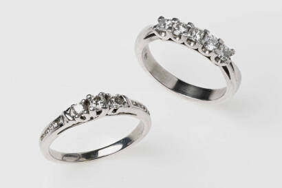 Two diamond rings, one marked set with five princess and round brilliant cut diamonds. The other with three round brilliant cut diamonds and channel set shoulders. One marked Platinum. Weight 8.13 grams. Size L.