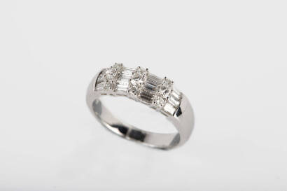 A diamond ring, twelve baguette diamonds are set between three rows of three round briliant diamonds of estimated total weight 0.58 carat. 18ct white gold. Weight 5.7 grams. Size M.&nbsp;