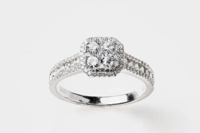 A diamond ring, five round brilliant diamonds in a central cluster set with a diamond halo and diamond set shoulders.18ct white gold. Weight 3.8 grams. Size M.&nbsp;