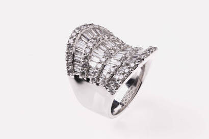 A diamond ring, the four rows of tapered baguettes bordered with rows of round brilliant diamonds of estimated total weight 4.38 carats.18ct white gold. Weight 23.5 grams. Size N.&nbsp;