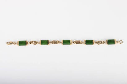 A greenstone and gold gate bracelet, the vintage bracelet set with five oblong nephrite jade bars in gold capped links and joined by triple bar gate links. 9ct yellow gold. Weight 15.6 grams. Length 200mm.&nbsp;