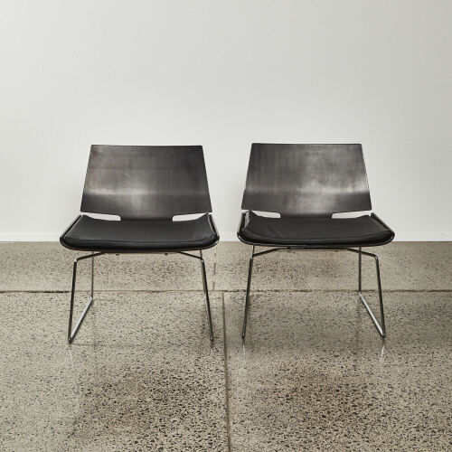 A Pair Of Black Modernist Chairs Moulded Ply With Leather Squabs