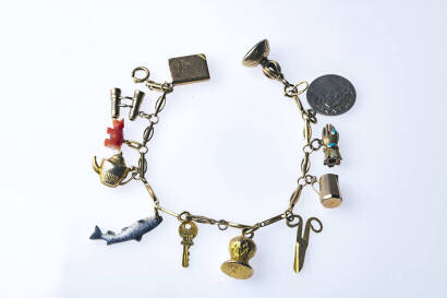 A gold charm bracelet, the oval fancy link bracelet hung with twelve various charms. 9ct yellow gold. Weight 25.7 grams. Length 16cm.&nbsp;