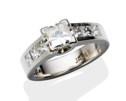 An 0.82 carat solitaire diamond ring, the princess cut diamond, corner set within three princess cut diamonds to each shoulder of estimated total weight 0.75 carat. Platinum. Weight 8.37 grams. Size K.