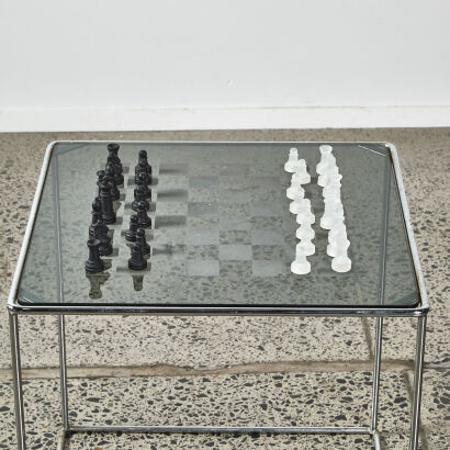 A Glass And Chrome Chess Table With Resin Chess Set