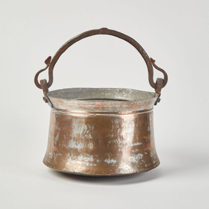 A Rustic Middle Eastern Copper Pot With Cast Iron Handle